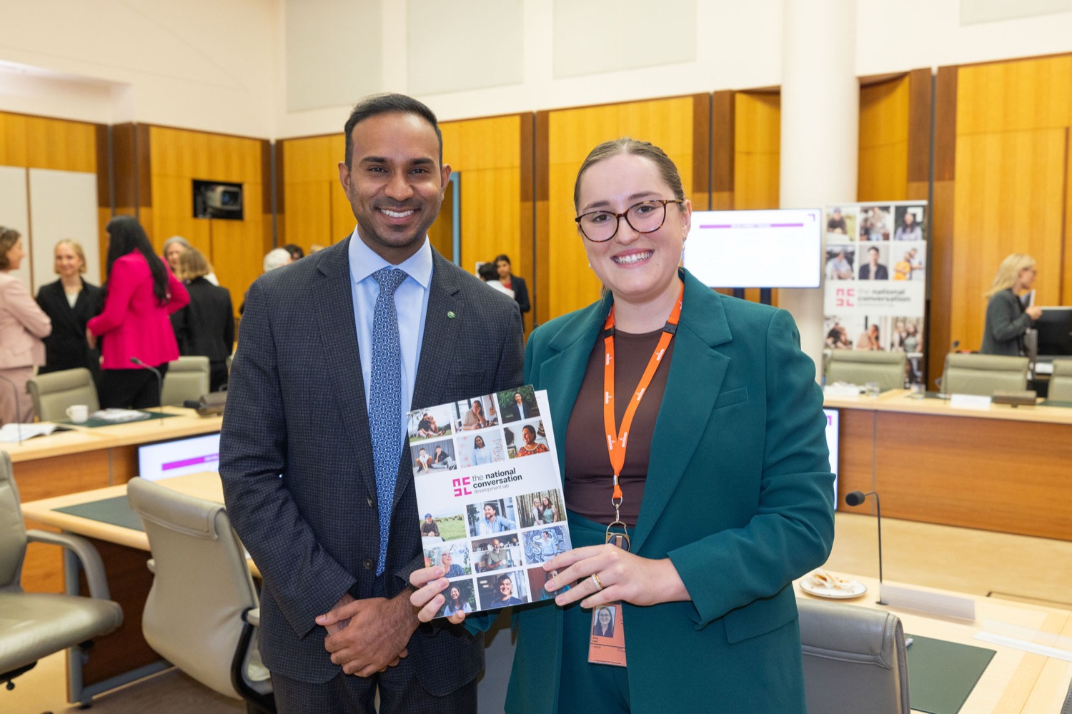 Two attendees holding the Portraits of Our Future report.