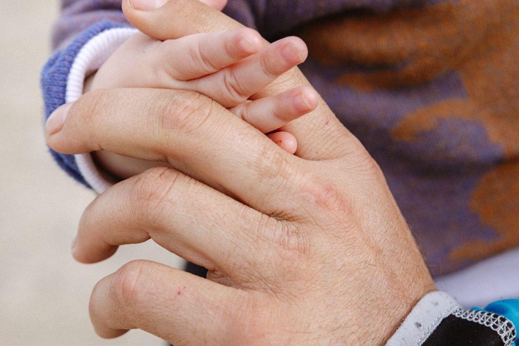 Two people with clasped hands in conversation